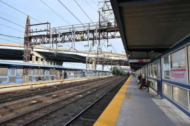 Platform at Bridgeport train station with the red Bridgeport sign, tracks and overhead power lines